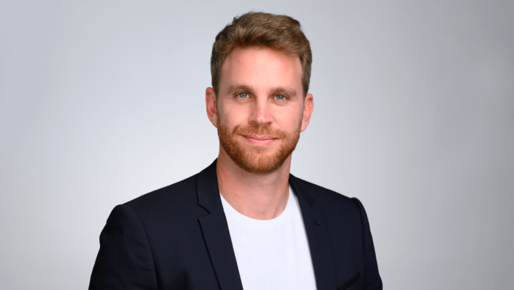 headshot of man in jacket and t-shirt
