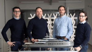 Vitruvius Yacht Design team poses with model yacht.