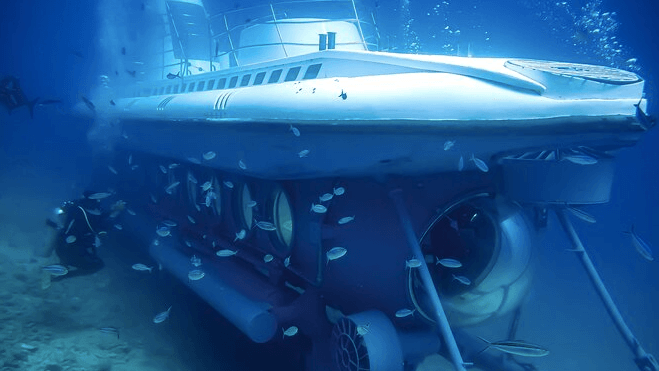 Submarine vessel underwater on wheels with fish swimming around it