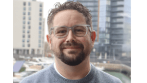 man with glasses smiling at camera