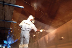 man spraying coppercoat antifoul on superyacht hull