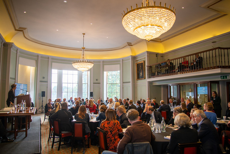 Delegates sitting round tables listening to guest speaker at Marine Charities Group conference in 2019