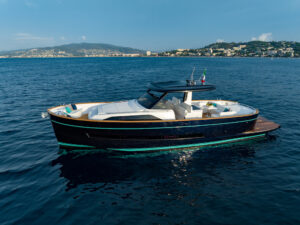 Barca con ponte aperto che galleggia sulle coste della costa italiana.