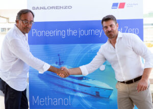 Two men shaking hands in front of Sanlorenzo poster after announcing agreement.