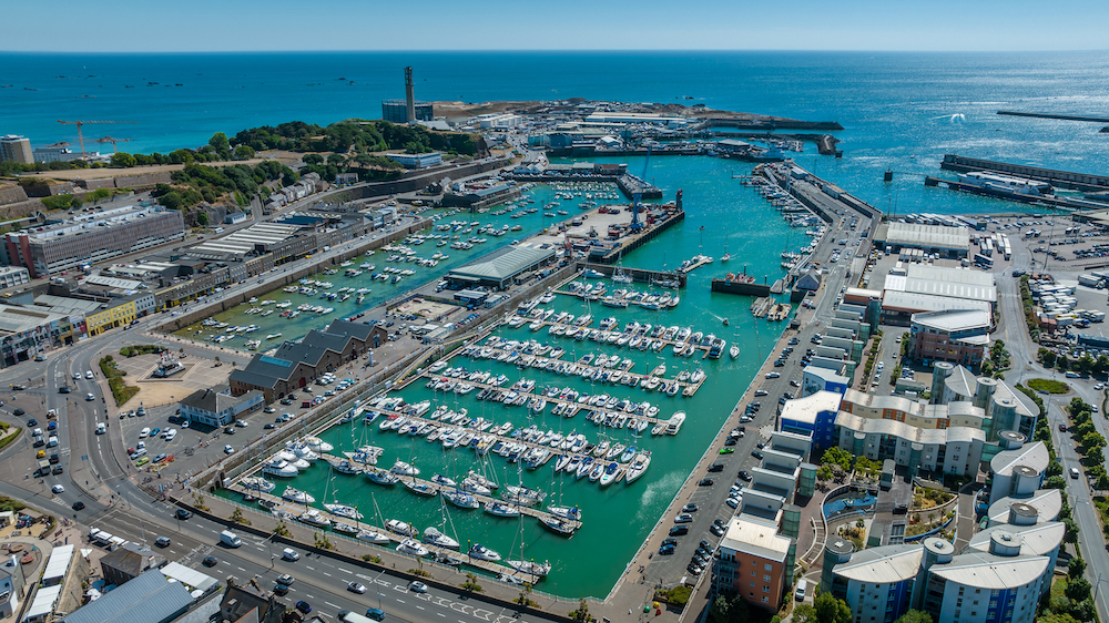 Aerial view of St Helier Marina in Jersey, Channel Islands, with lots of boats moored up to the pontoons.