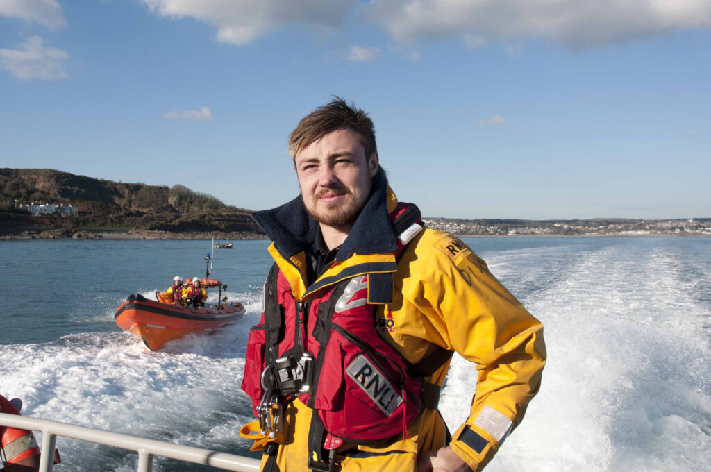 Exeter chiefs and England rugby player Jack Nowell onboard Penlee RNLI all weather lifeboat with inshore lifeboat behind in support of the Penlee lifeboat station fundraising appeal.