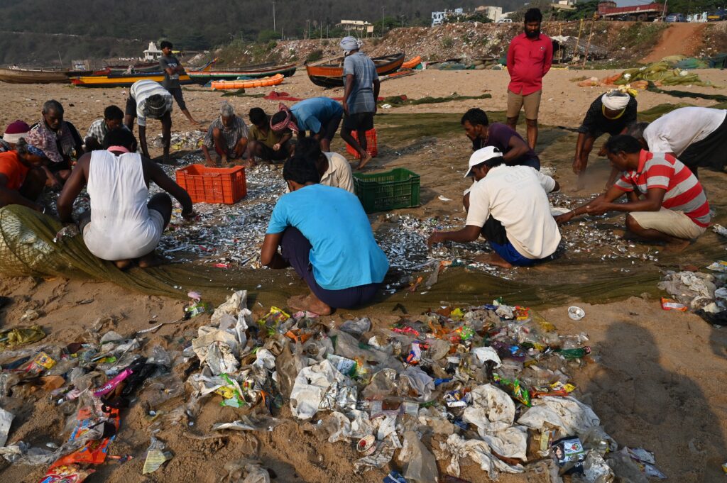 Fishermen sorting plastic waste from the fishing net, Visakhapatnam, India