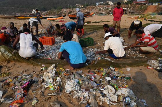 Fishermen sorting plastic waste from the fishing net, Visakhapatnam, India