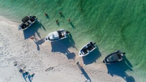 Aerial view of four motorboats on the shore at the tideline