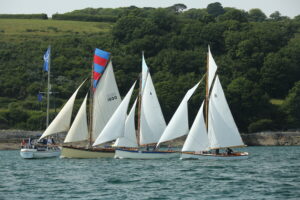 Group of classic sailing yachts with white sails