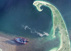 Aerial view of boat on the shore with a sit of land