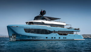Large blue hulled superyacht with white superstructure