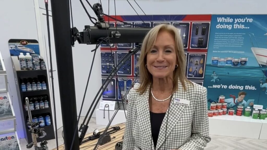 Suzanne Blaustone de Barton Marine fica em frente a um bote em um salão de exposições