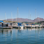 Boats moored on pontoons with mountain backdrop