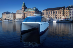 Elektrischer Fährkatamaran Candela mit Stockholmer Uferpromenade dahinter