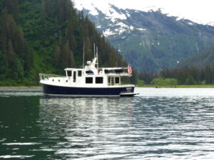 American Tugs trawler yacht on lake with mountain backdrop