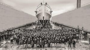 Crowd of people in front of the bow of a large motor yacht