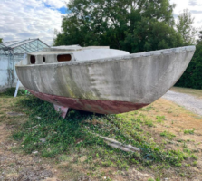 An abandoned boat on the hard standing in a state of disrepair.