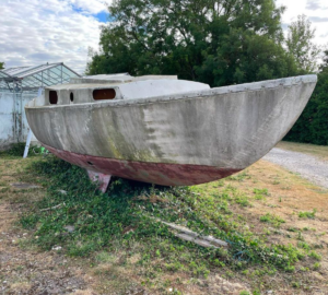 An abandoned boat on the hard standing in a state of disrepair.