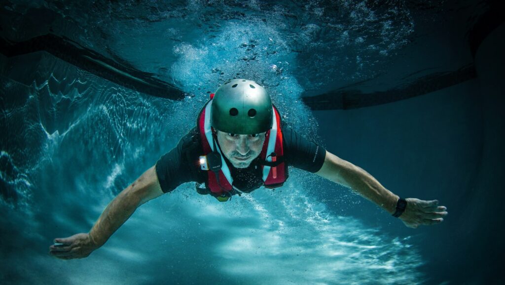 Person swimming underwater wearing a throwraft lifejacket