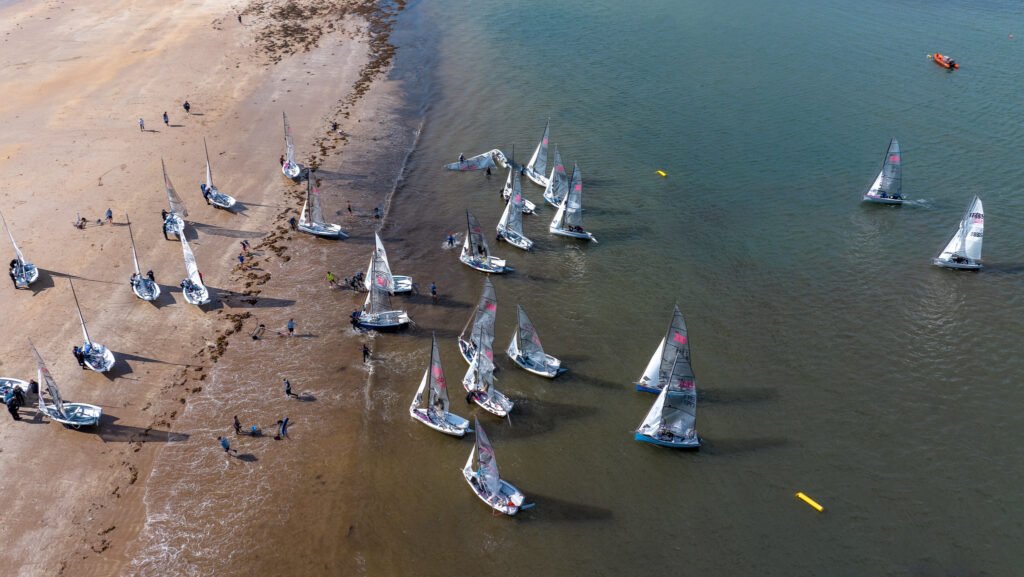 Sailing dinghies coming up to a beach