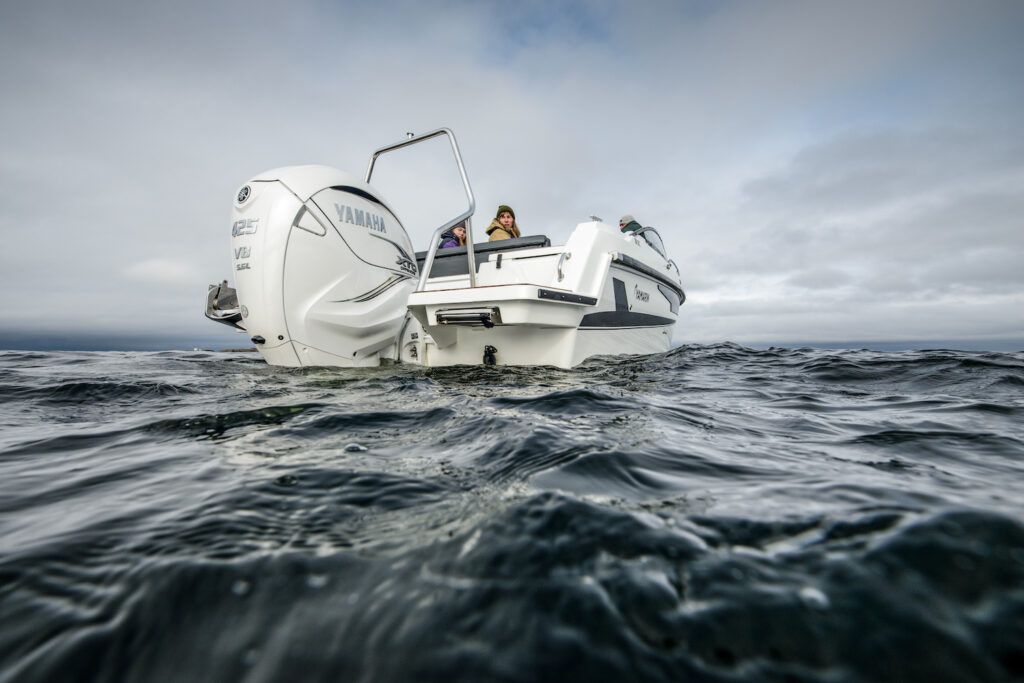 Waterniveauweergave van een witte boot met een grote witte buitenboordmotor