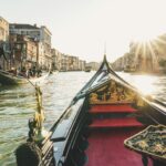 Bow of a gondola as sun sets on Venice canal