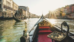 Bow of a gondola as sun sets on Venice canal