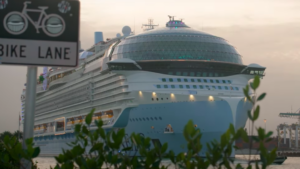 Icon of the Seas, het grootste cruiseschip ter wereld, afgebeeld op de rivier naast het bord Bike Lane