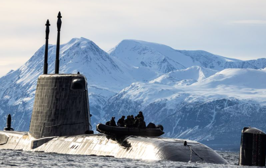 Dinghy with sailors on top of Royal Navy submarine in icy conditions
