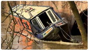 Barco angosto atrapado en el costado del puente en aguas altas después de la tormenta Henk