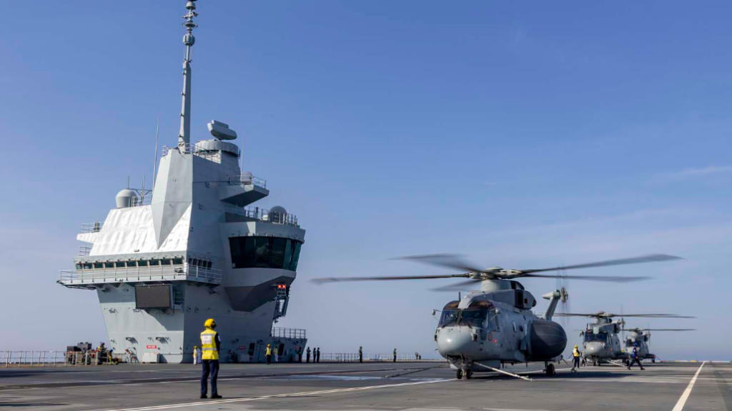 three helicopters line up on aircraft carrier