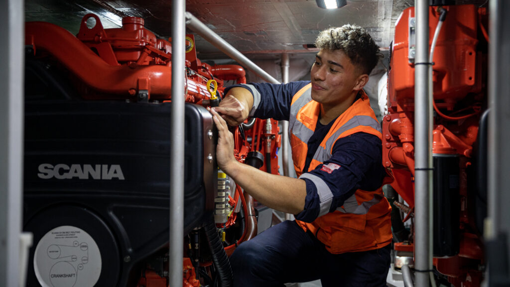 El aprendiz de ingeniería Ralphy Whiffen trabaja en el Centro de botes salvavidas para todo clima (ALC) del RNLI. Tomada para la revista Lifeboat Verano 2022.