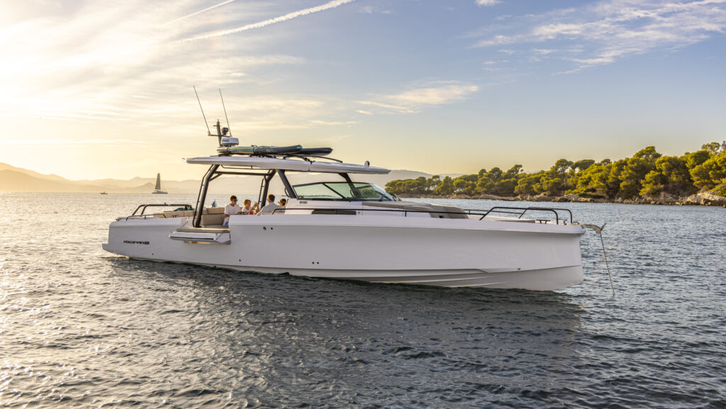 белая 45-футовая моторная лодка с солнечным светом, падающим на корму воды