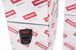 Porte-clés en gros plan à côté de l'emballage du logo Yanmar rouge