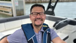 man smiling wearing life jacket on boat