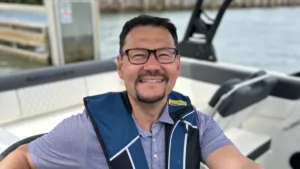 ボート上でライフジャケットを着て笑っている男性