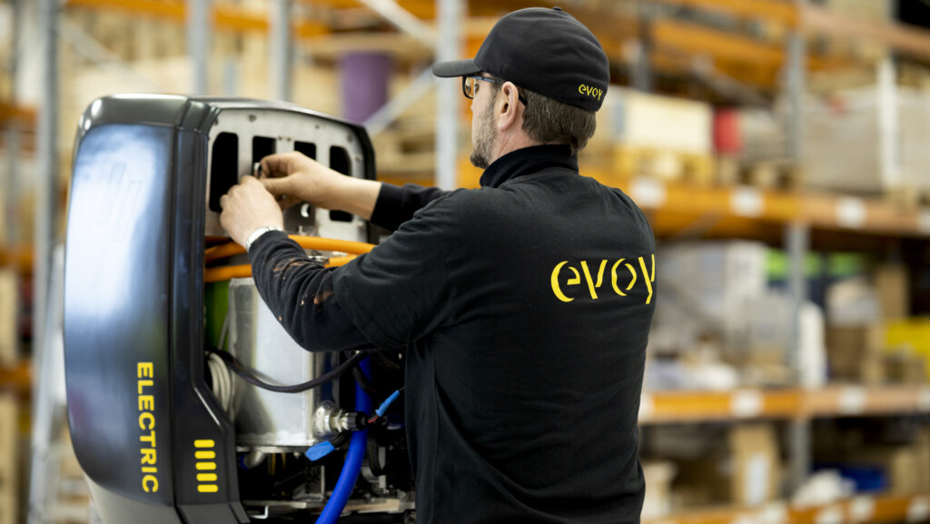 Evoy ジャケットを着て、黒の洗練された Evoy 電気エンジンを操作する男性