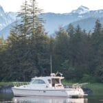 Aspen catamaran on water with stunning backdrop of mountains and trees
