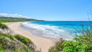 a sandy beach with bright blue water