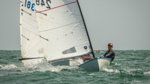 Een matroos in een boot met veel zeil. . . het type waarvan Sustainable Sailing zegt een manier te hebben gevonden om te recyclen.