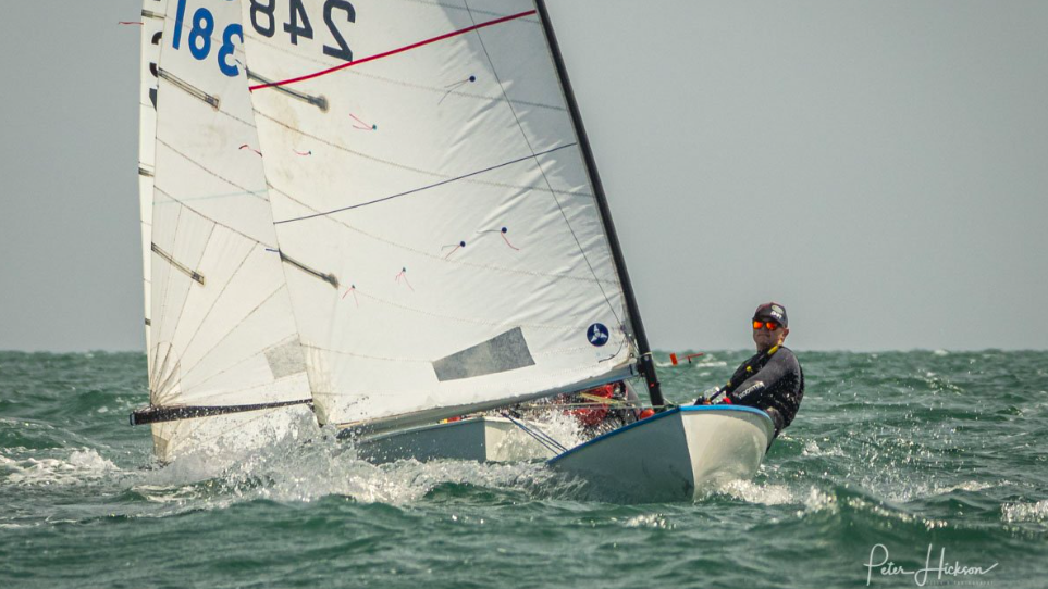 Un marin dans un bateau avec beaucoup de voiles visibles. . . le type que Sustainable Sailing dit avoir trouvé un moyen de recycler.