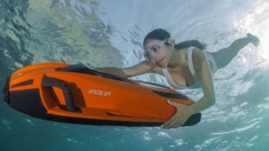 سباح تحت الماء، ممسكًا بلعبة مائية حيث تقدم iAqua تجارة الألعاب المائية الإضافية