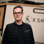 X Shore CEO Rene Hansen man standing in front of boat bow