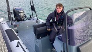 boy sits on boat that he's using to circumnavigate UK and Northern Ireland in eRIB challenge