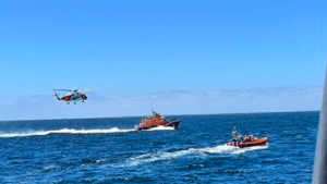 helicopter follows two RNLI rescue craft