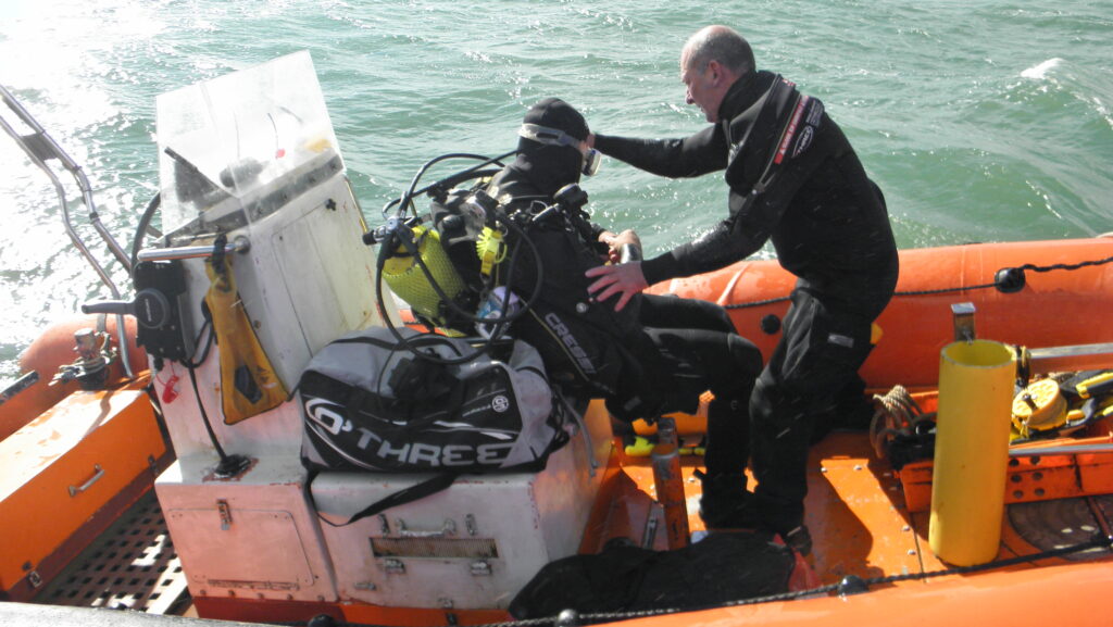 Two scuba divers in a RIB preparing for a dive