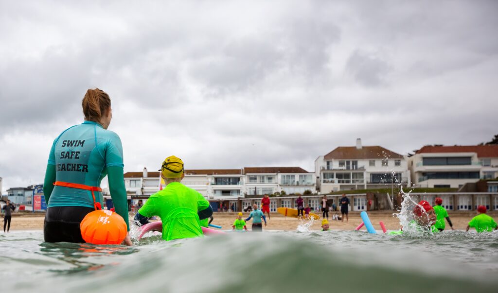 children in shallow water with buoyancy aids