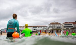 children in shallow water with buoyancy aids