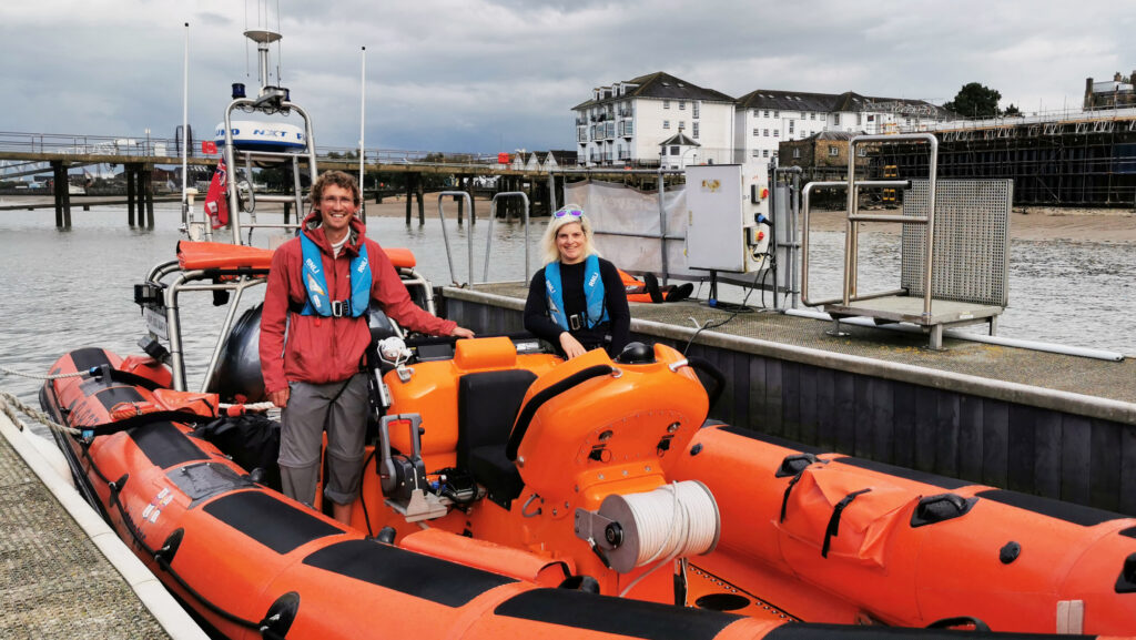 Adventurer Ed Pratt standing on Gravesend's Atlantic 85 with RNLI Commander Karla.